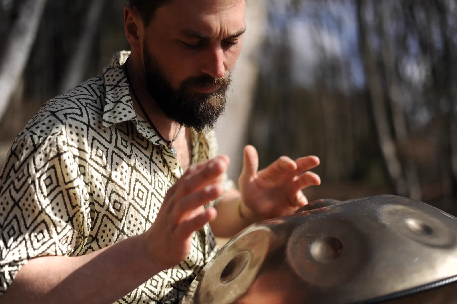 Simon's hands on a handpan in the forest