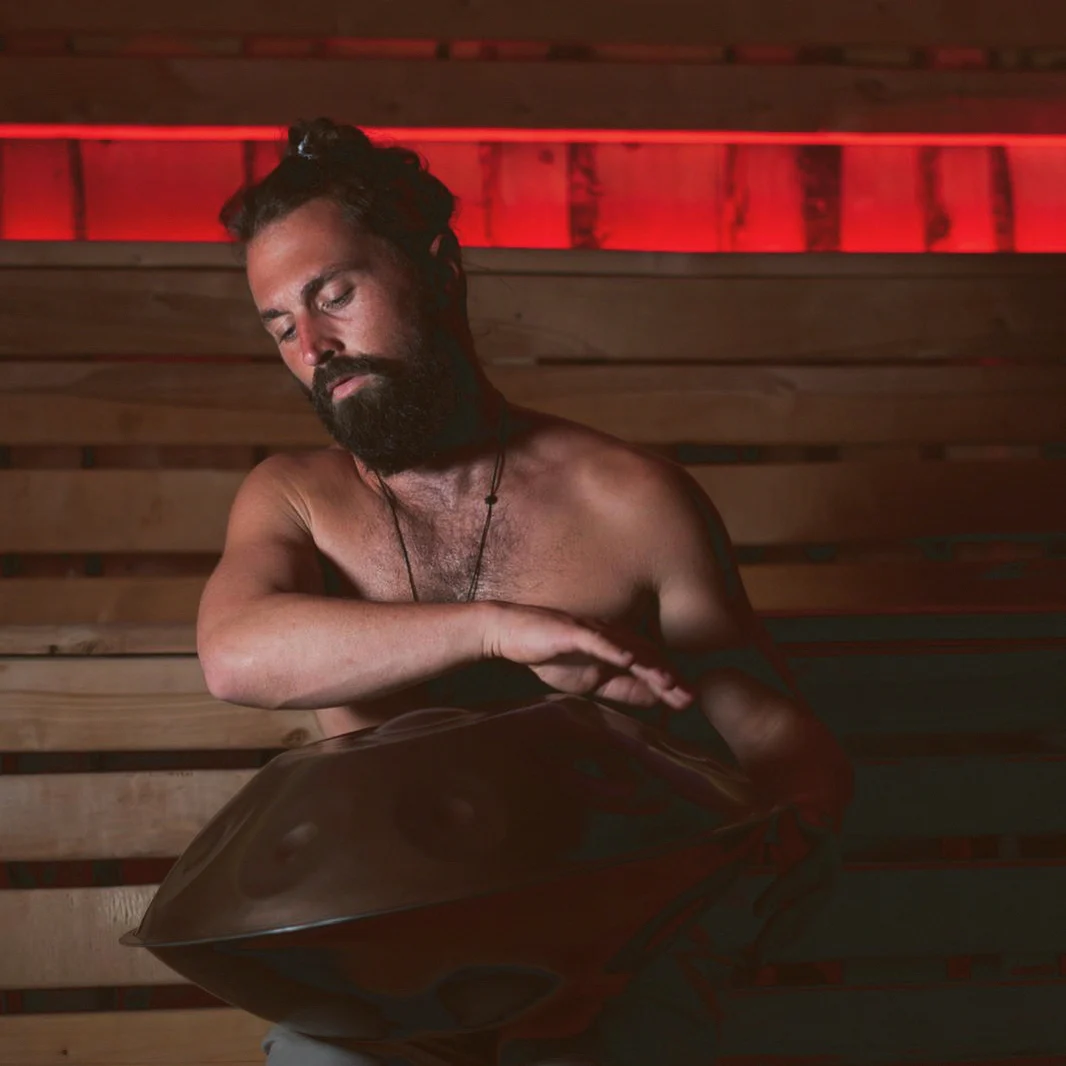 Simon plays the handpan in a sauna in red light