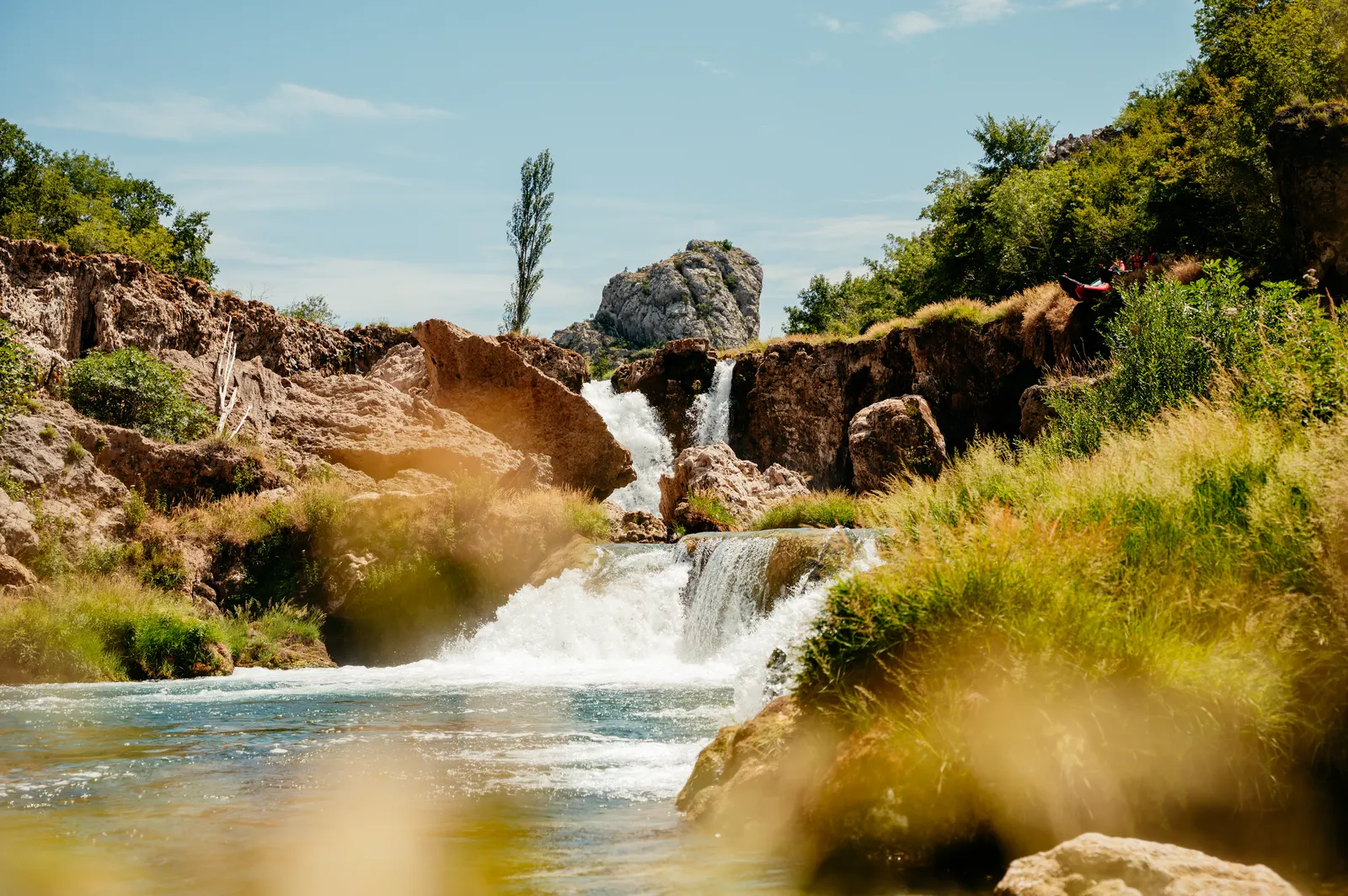 Waterfall over mossy rocks in a green valley